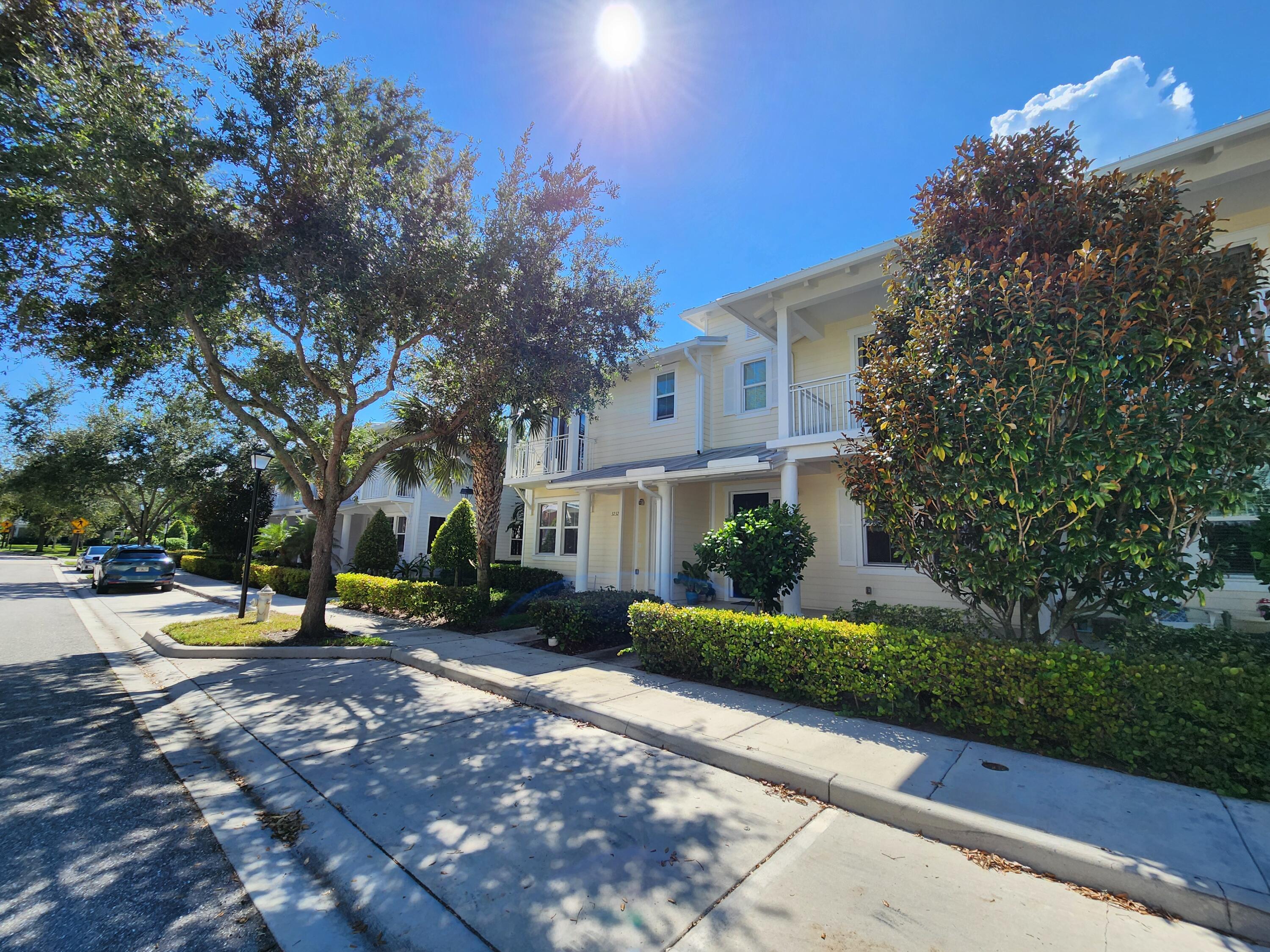 a row of palm trees in front of a house