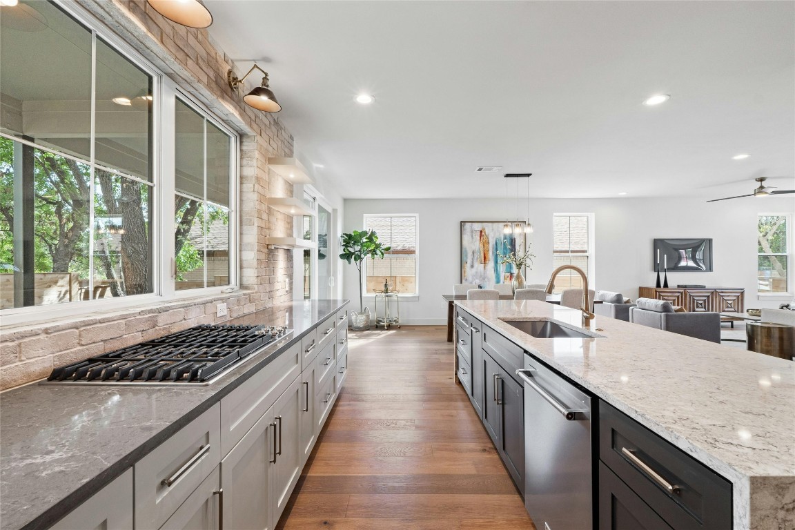 a kitchen with lots of counter top space a sink a window and stainless steel appliances