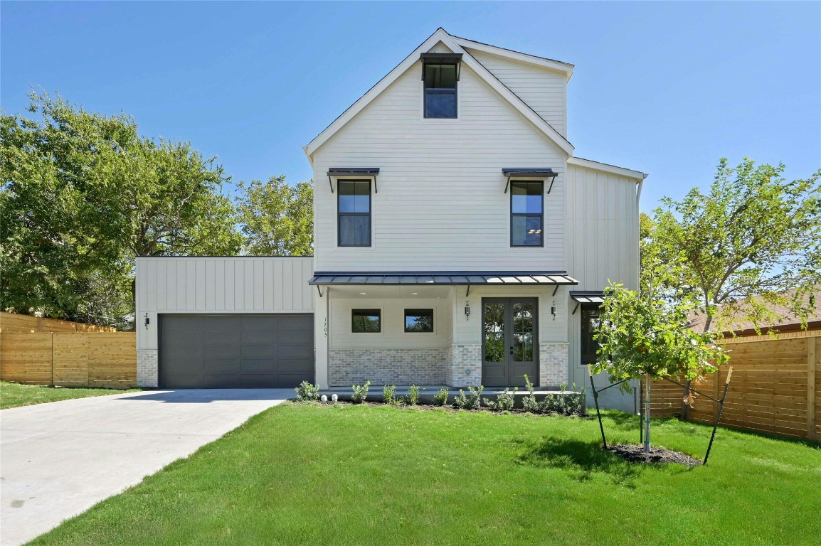 front view of a house with a yard and a garage