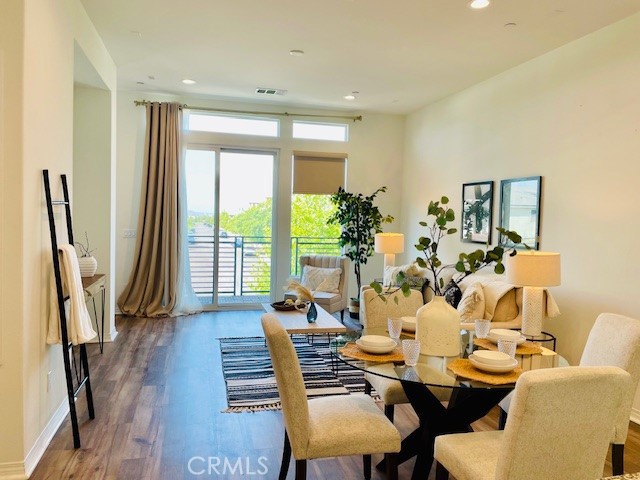 a dining room with furniture large window and wooden floor