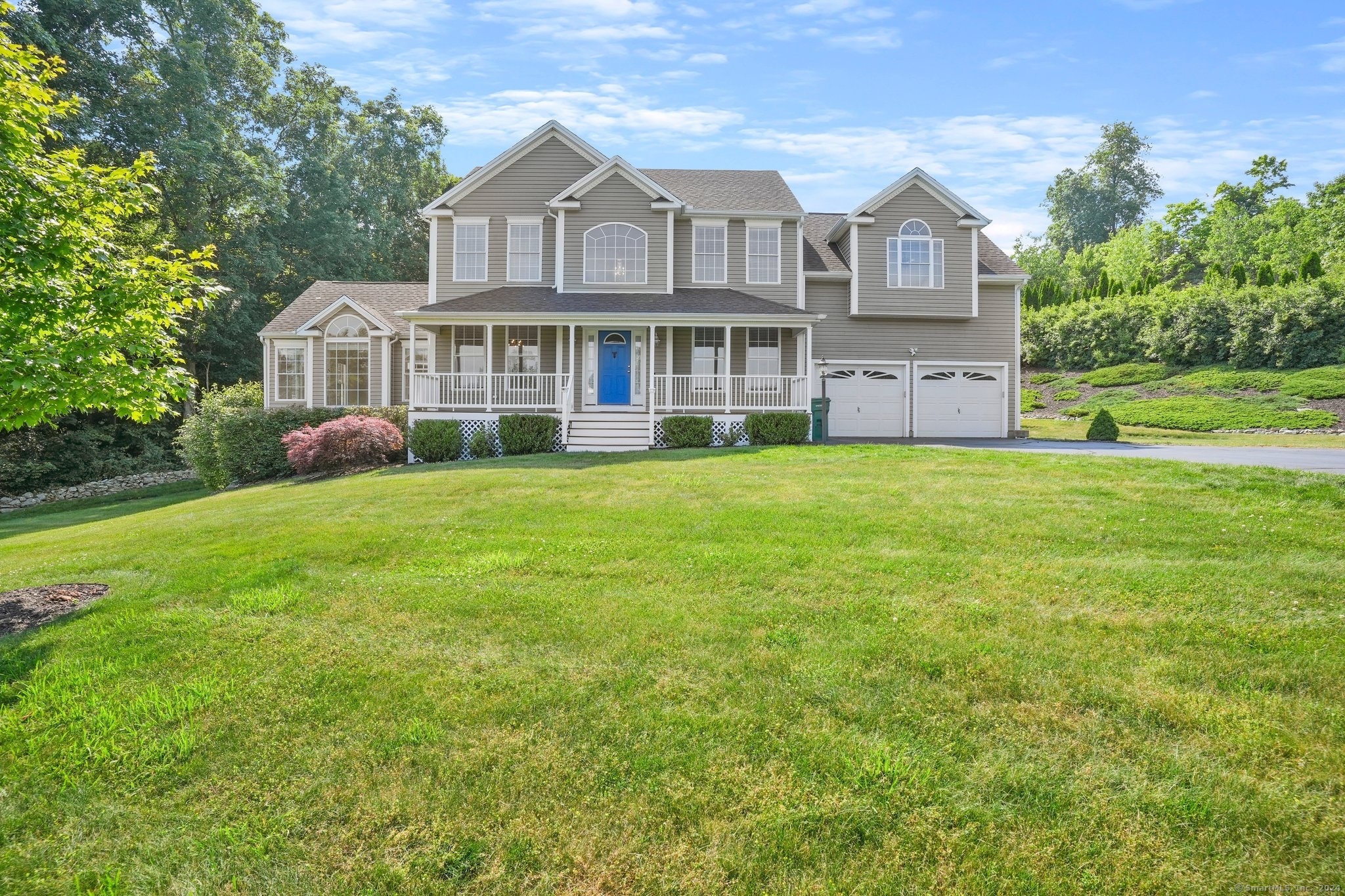 a view of a house with a big yard plants and large trees