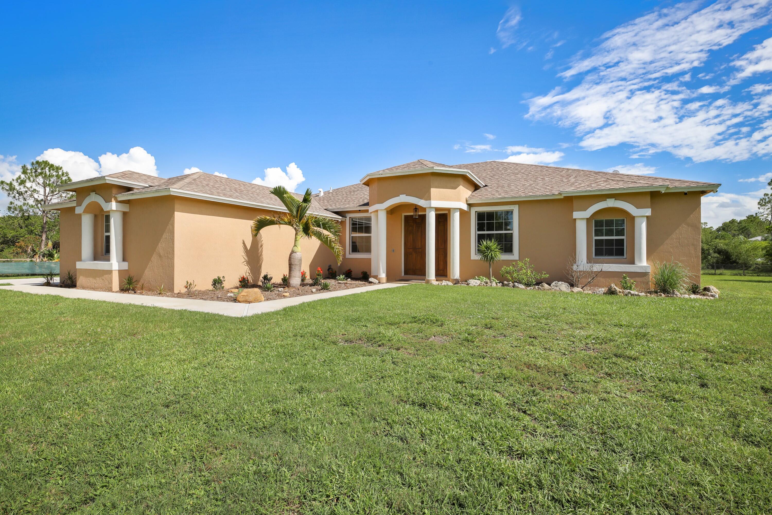 a front view of a house with a garden