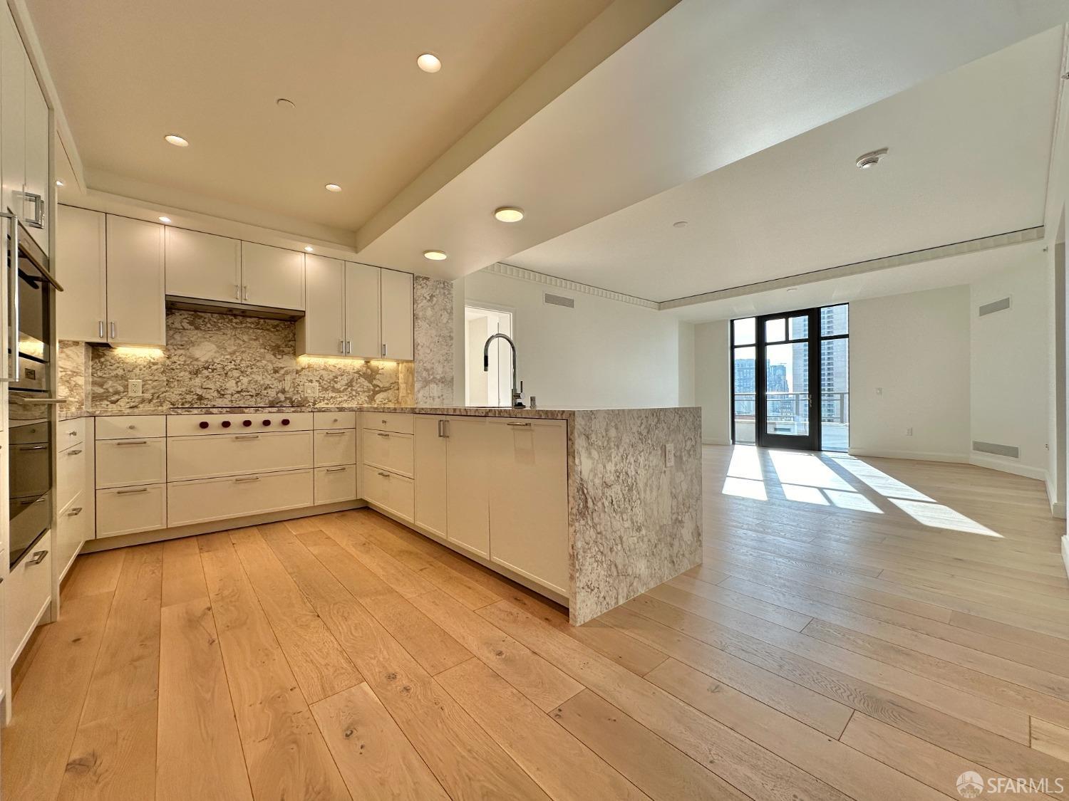 a large kitchen with stainless steel appliances granite countertop a large counter top and a floors