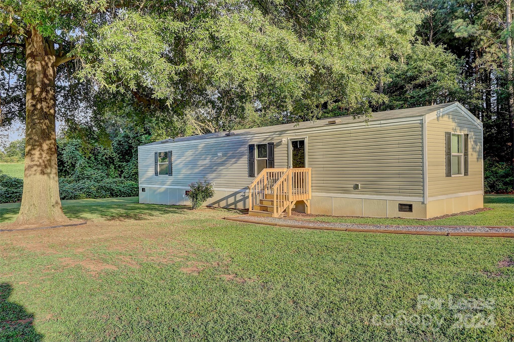 a view of a house with backyard and a tree