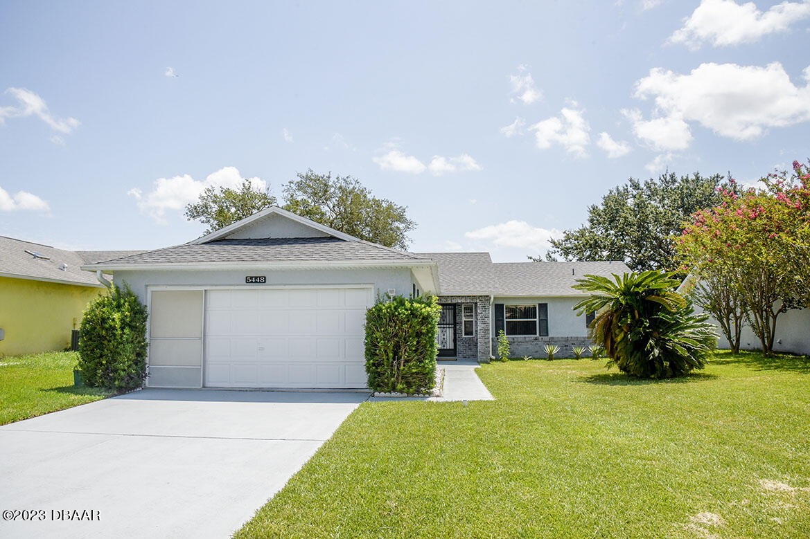 a front view of a house with a yard and garage