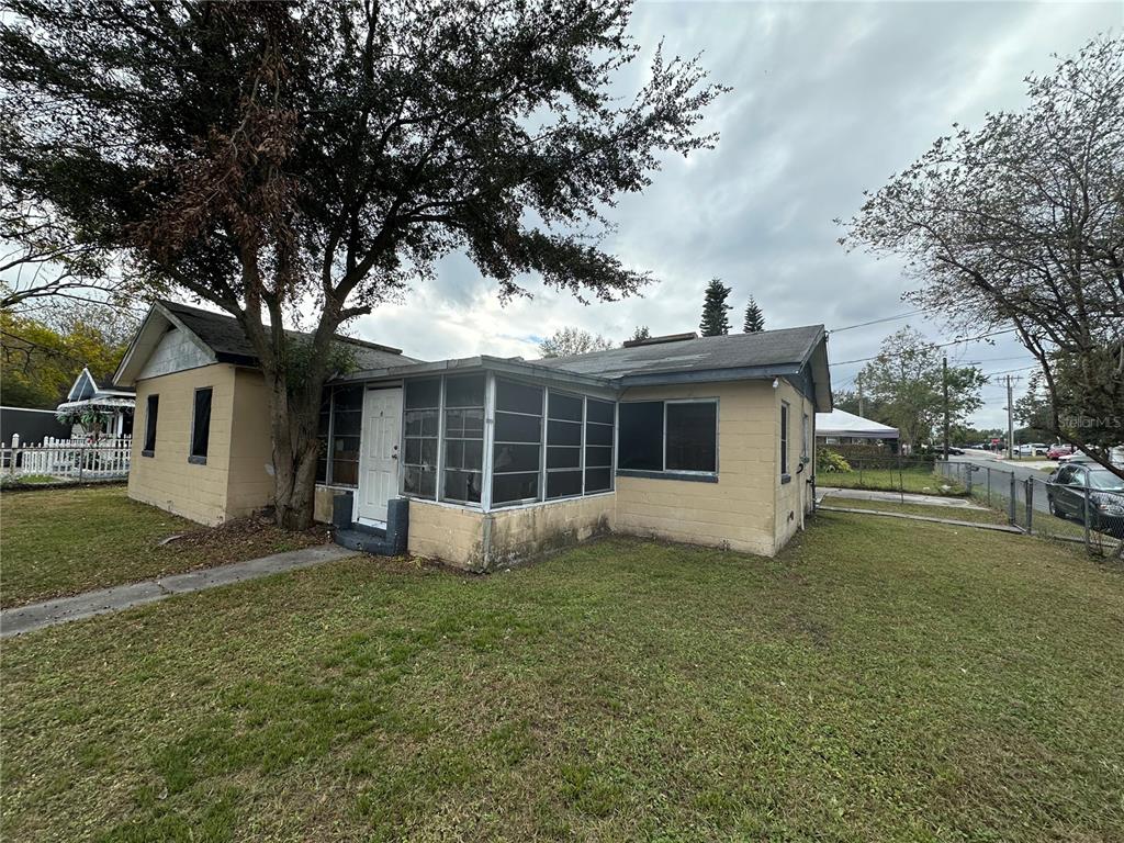 a view of a house with a yard and large tree