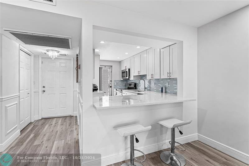 a kitchen with kitchen island a sink cabinets and wooden floor