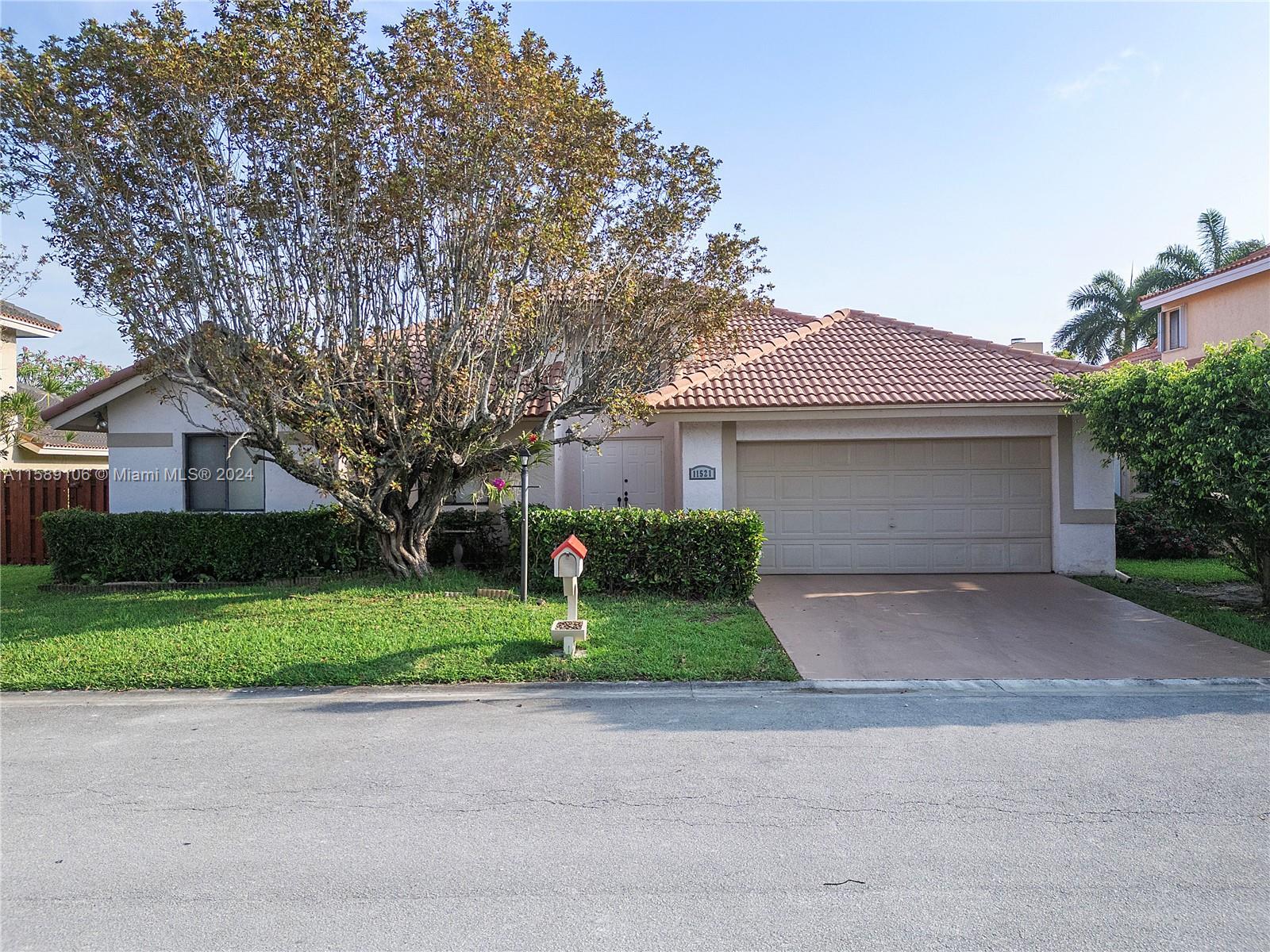 a front view of a house with a yard and a garage