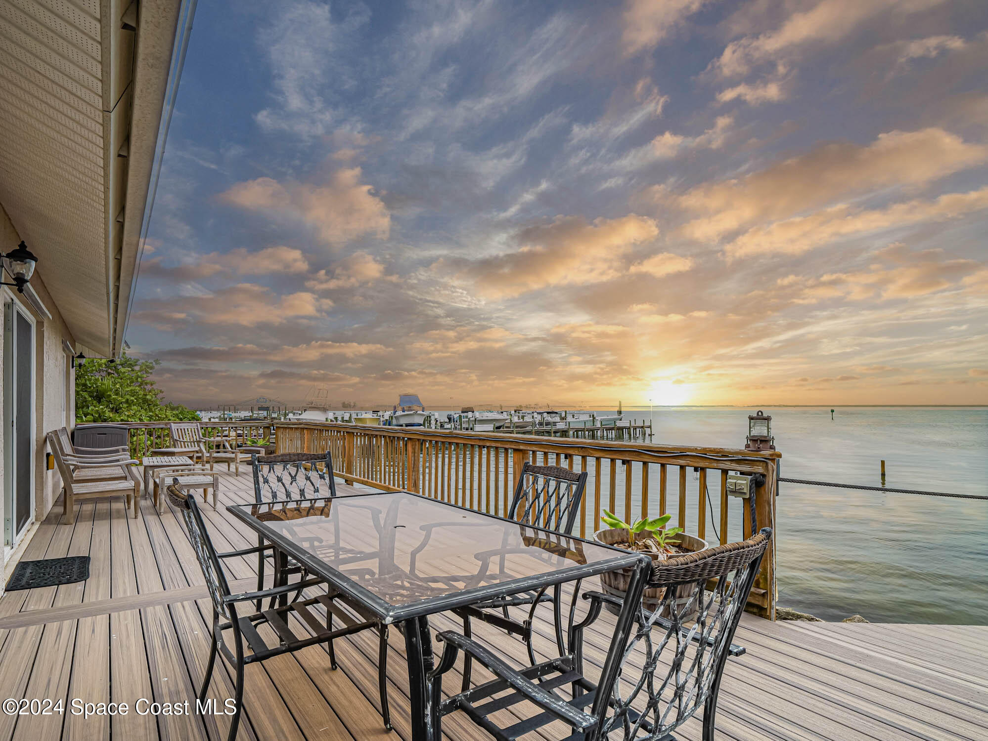 a view of a roof deck with table and chairs with wooden floor and fence