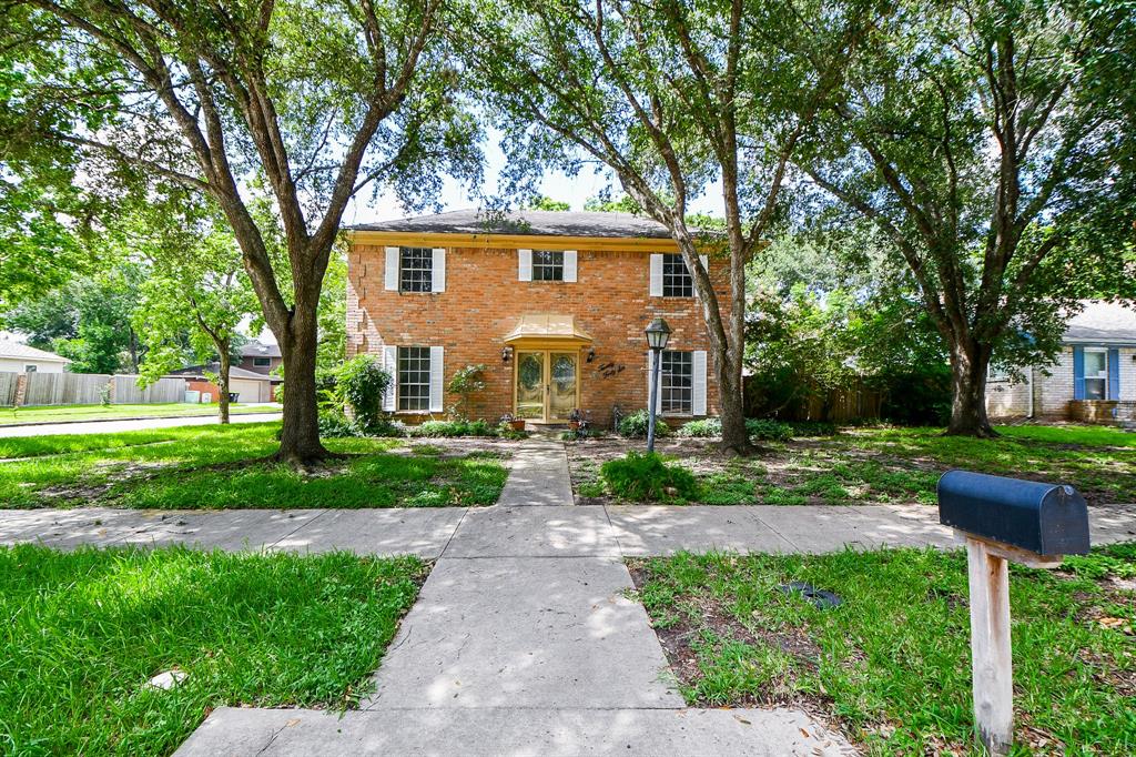 a front view of a house with a yard and trees