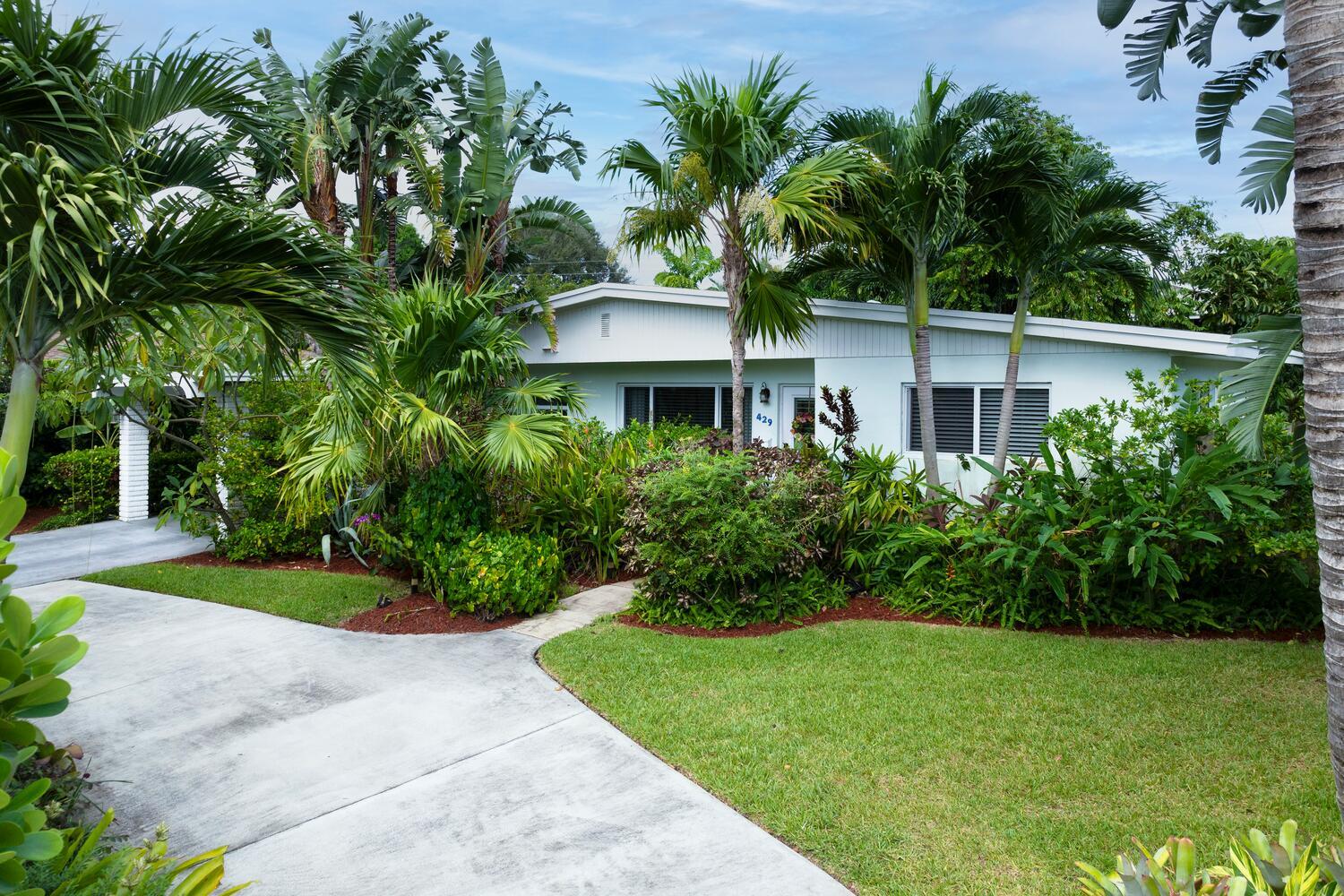 a front view of a house with a garden