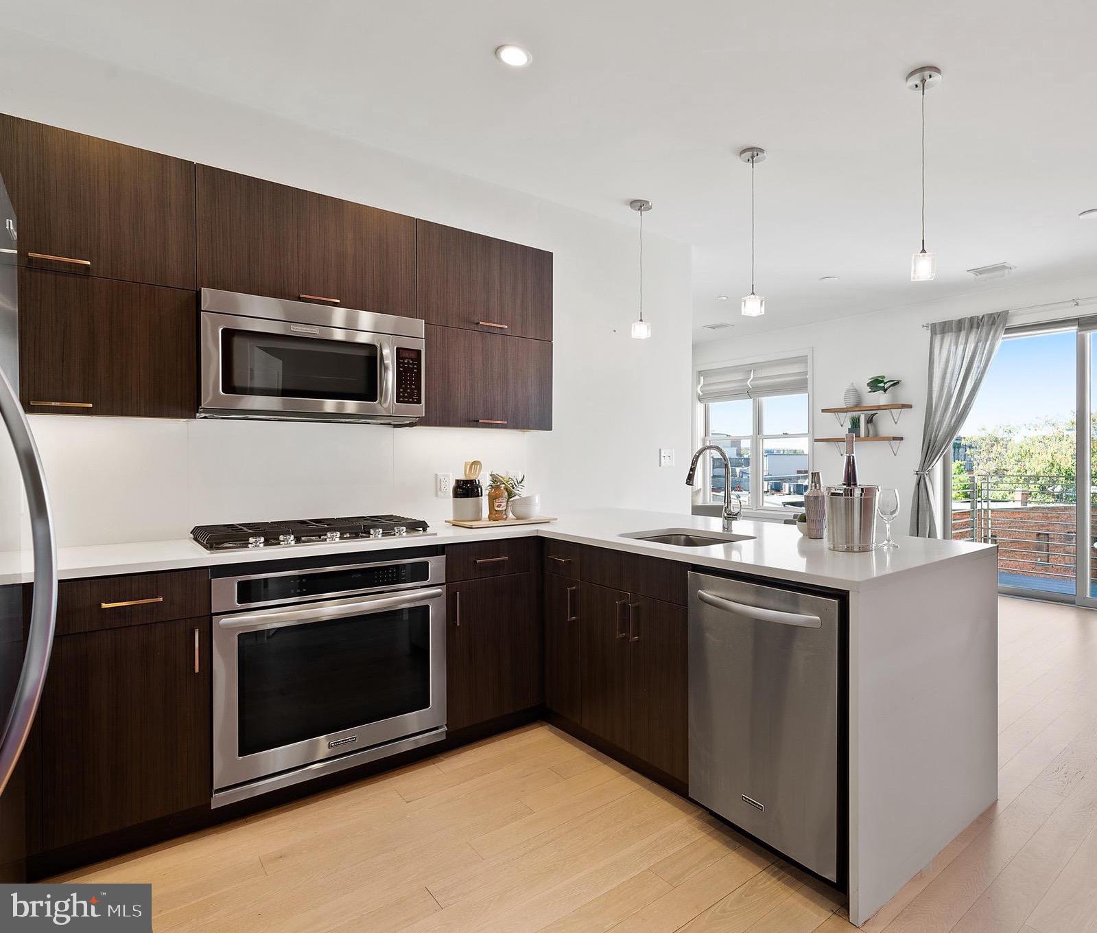 a kitchen with stainless steel appliances a stove microwave and sink