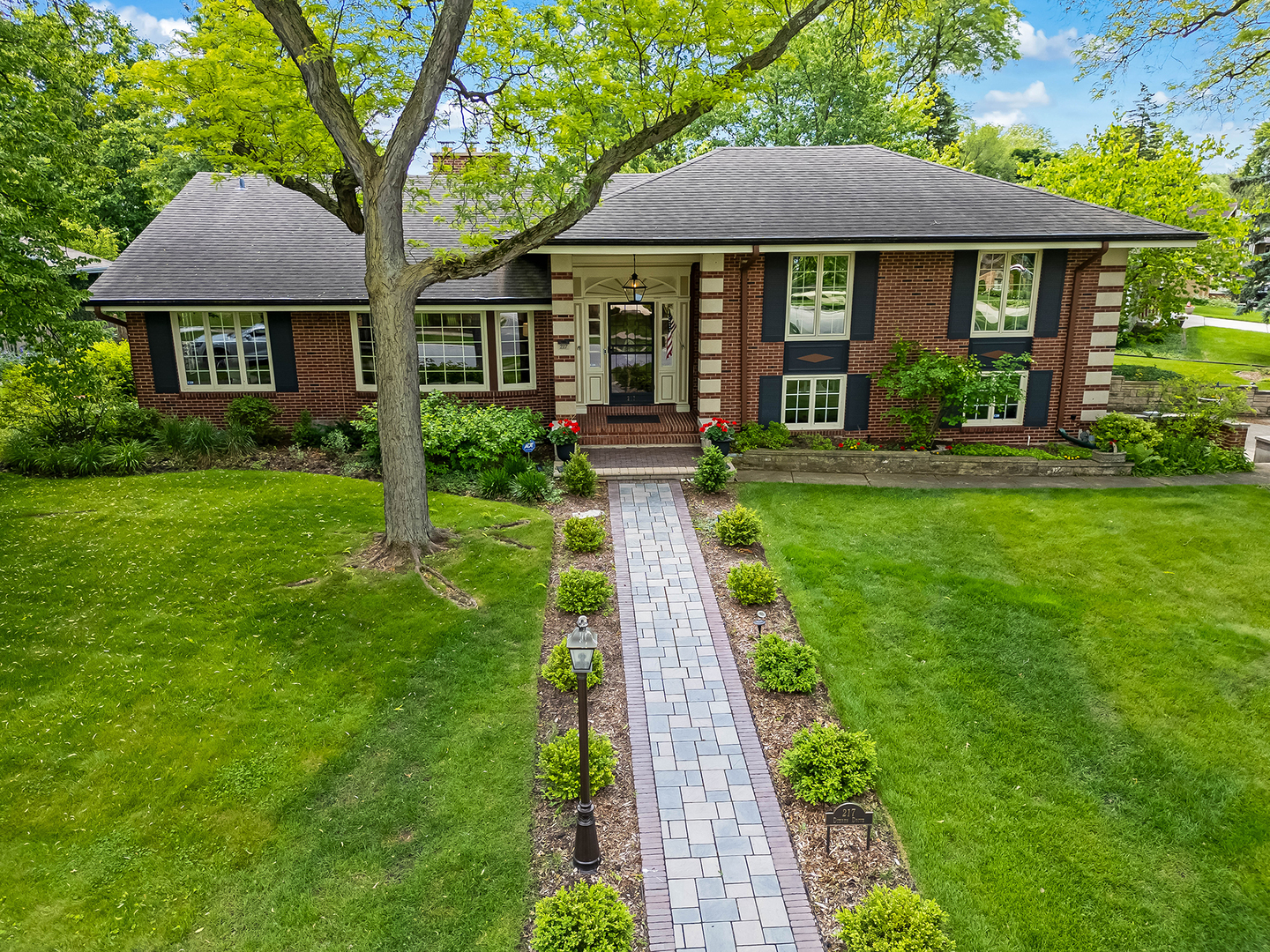 a view of a brick house with a yard and potted plants