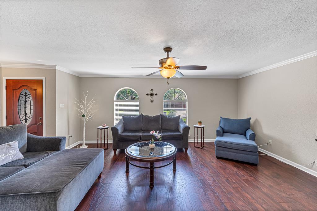 a living room with furniture and a wooden floor