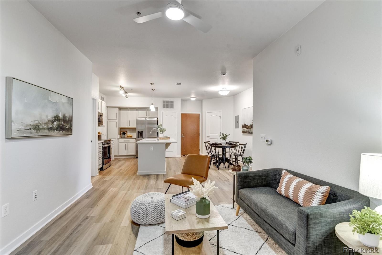 a living room with furniture and a view of kitchen