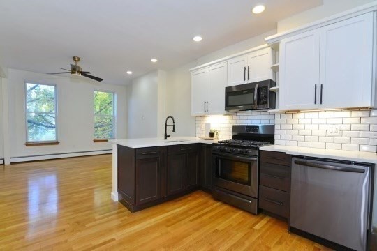 a kitchen with stainless steel appliances granite countertop a sink a stove top oven a counter space and cabinets