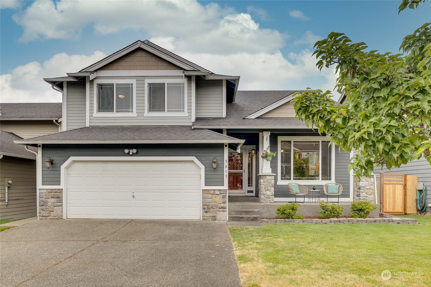 a front view of a house with a yard garage and trees