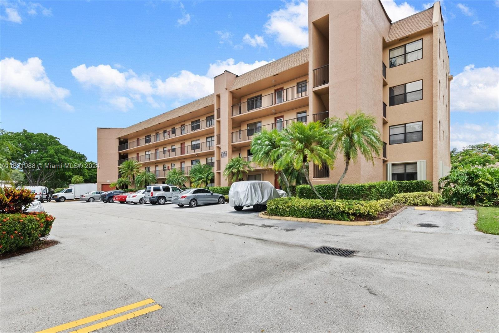 a view of a building with a bench and cars parked in front of it