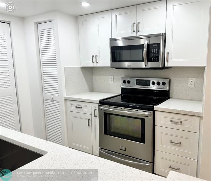 a kitchen with stainless steel appliances a stove a microwave and cabinets