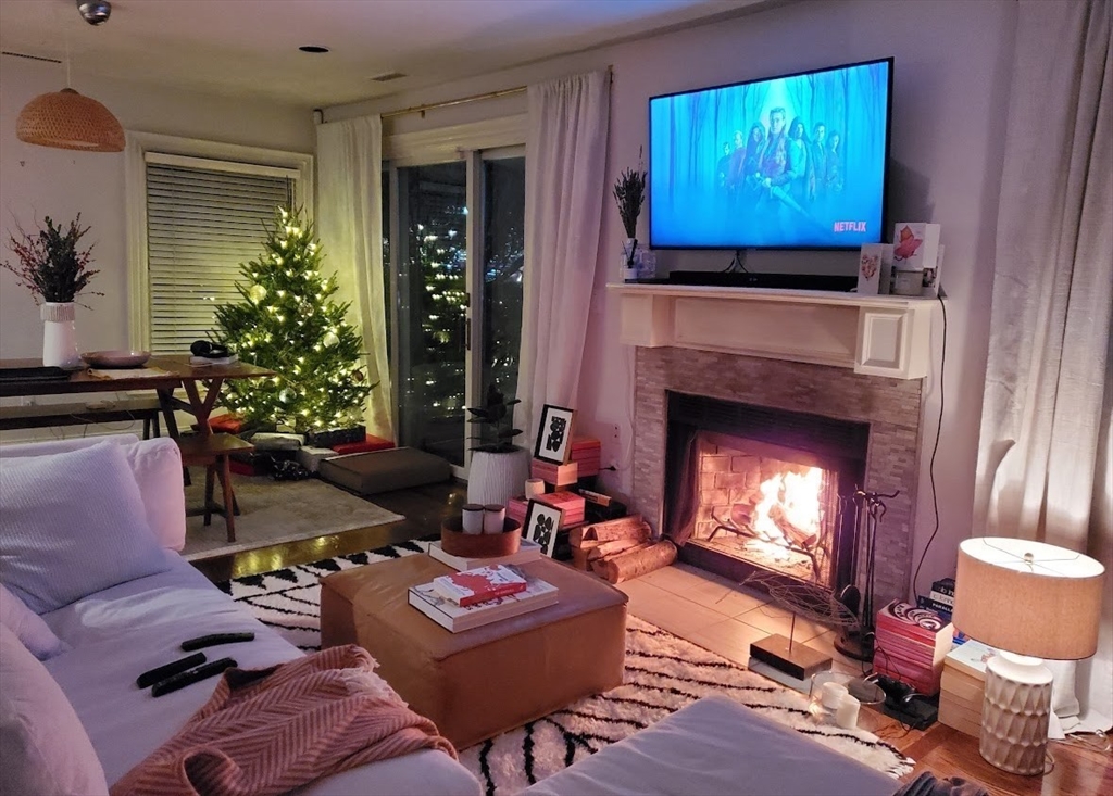 a living room with furniture a flat screen tv and a fireplace