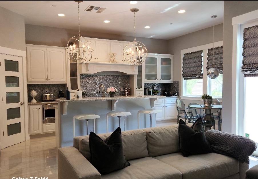 a living room with furniture a fireplace and a kitchen view