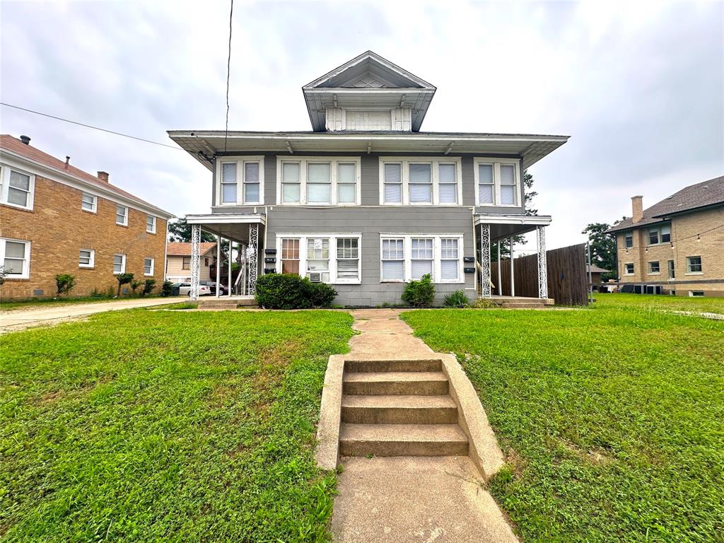 a front view of a house with a yard and fountain