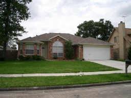 a view of a yard in front of a house with large trees