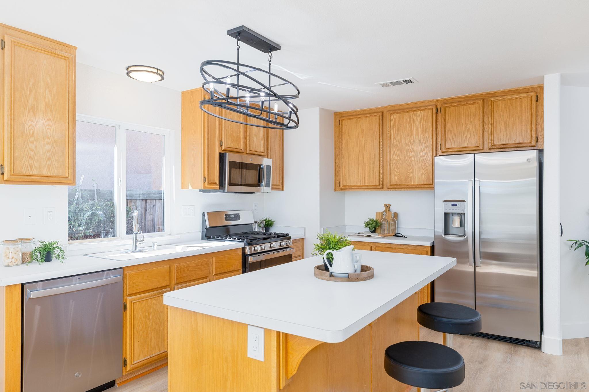 a kitchen with stainless steel appliances granite countertop a sink a refrigerator and a stove