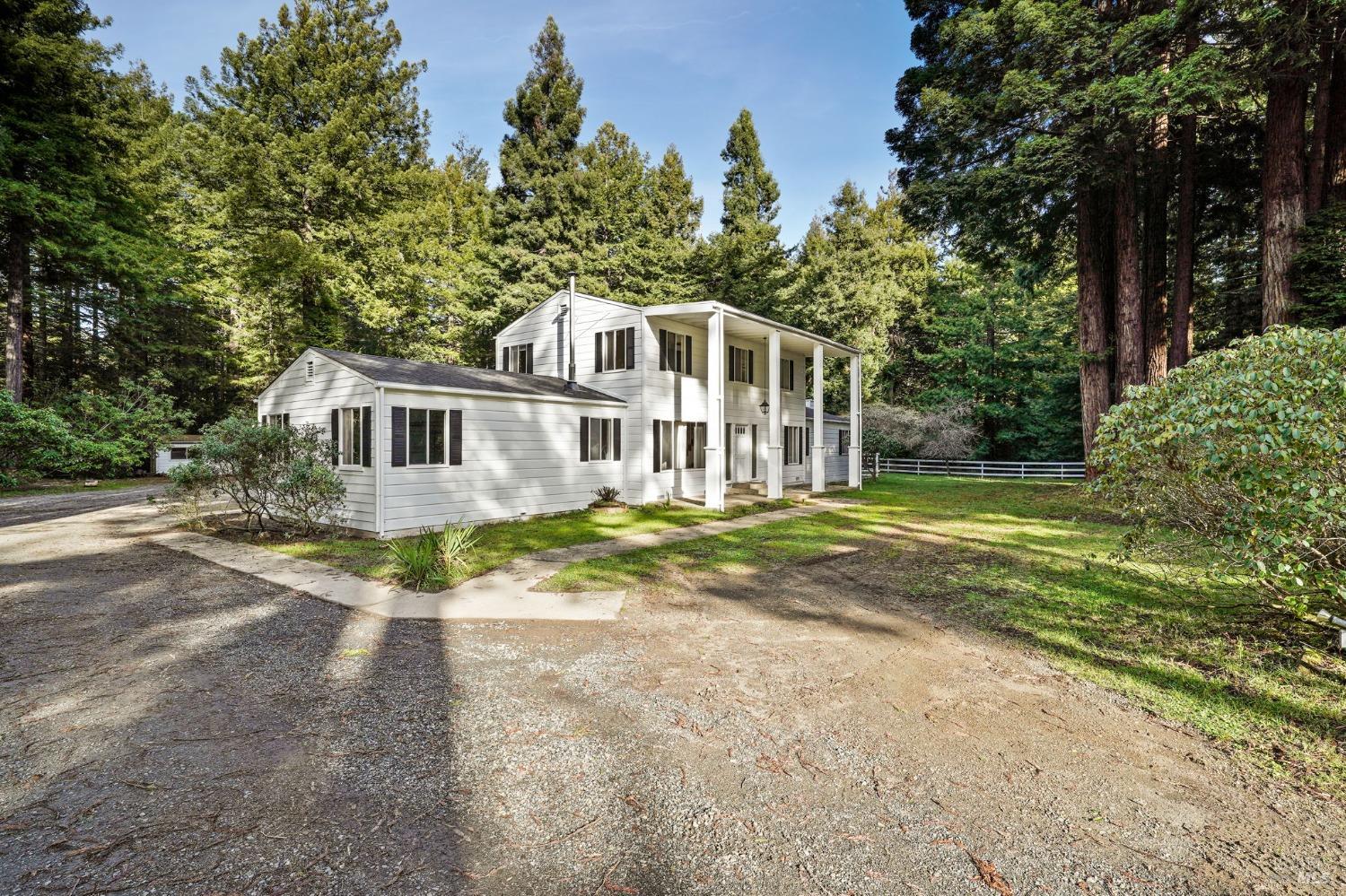 a view of a house with backyard and trees