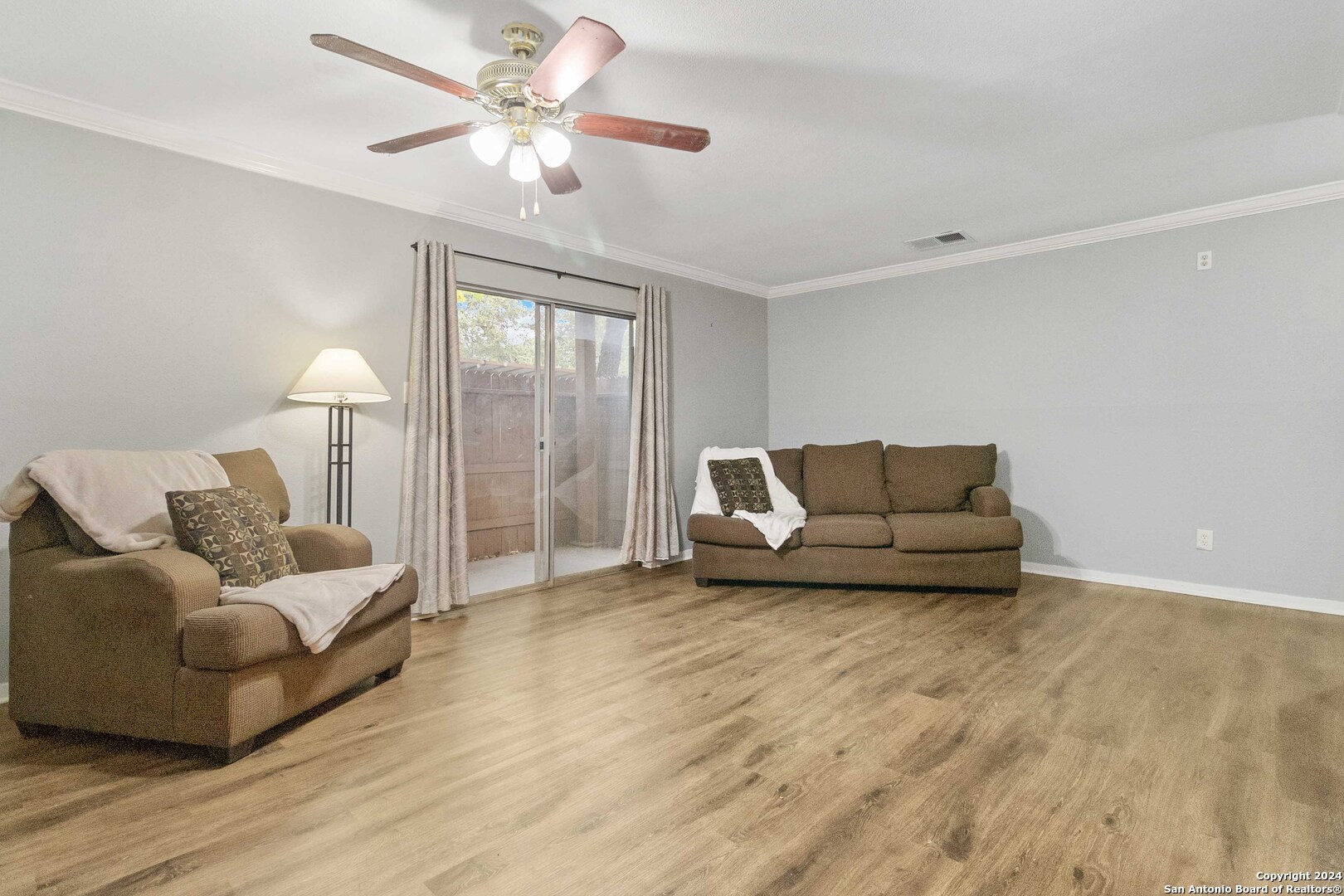 a living room with furniture and a ceiling fan