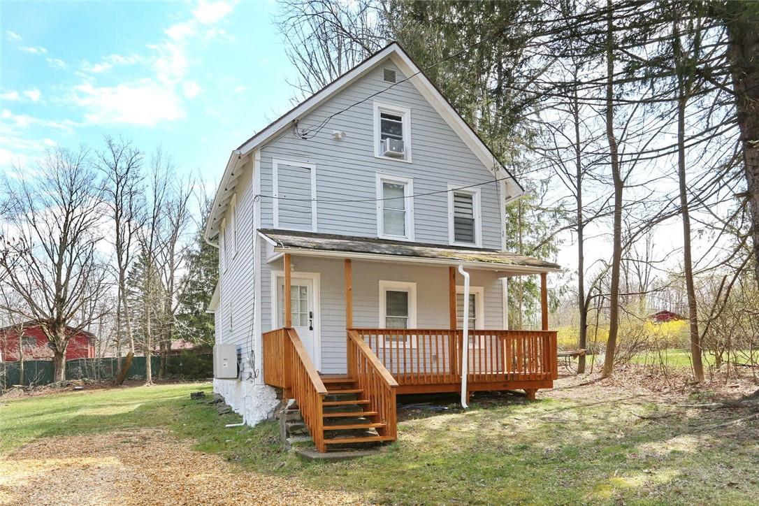 Rear view of property with cooling unit and a yard