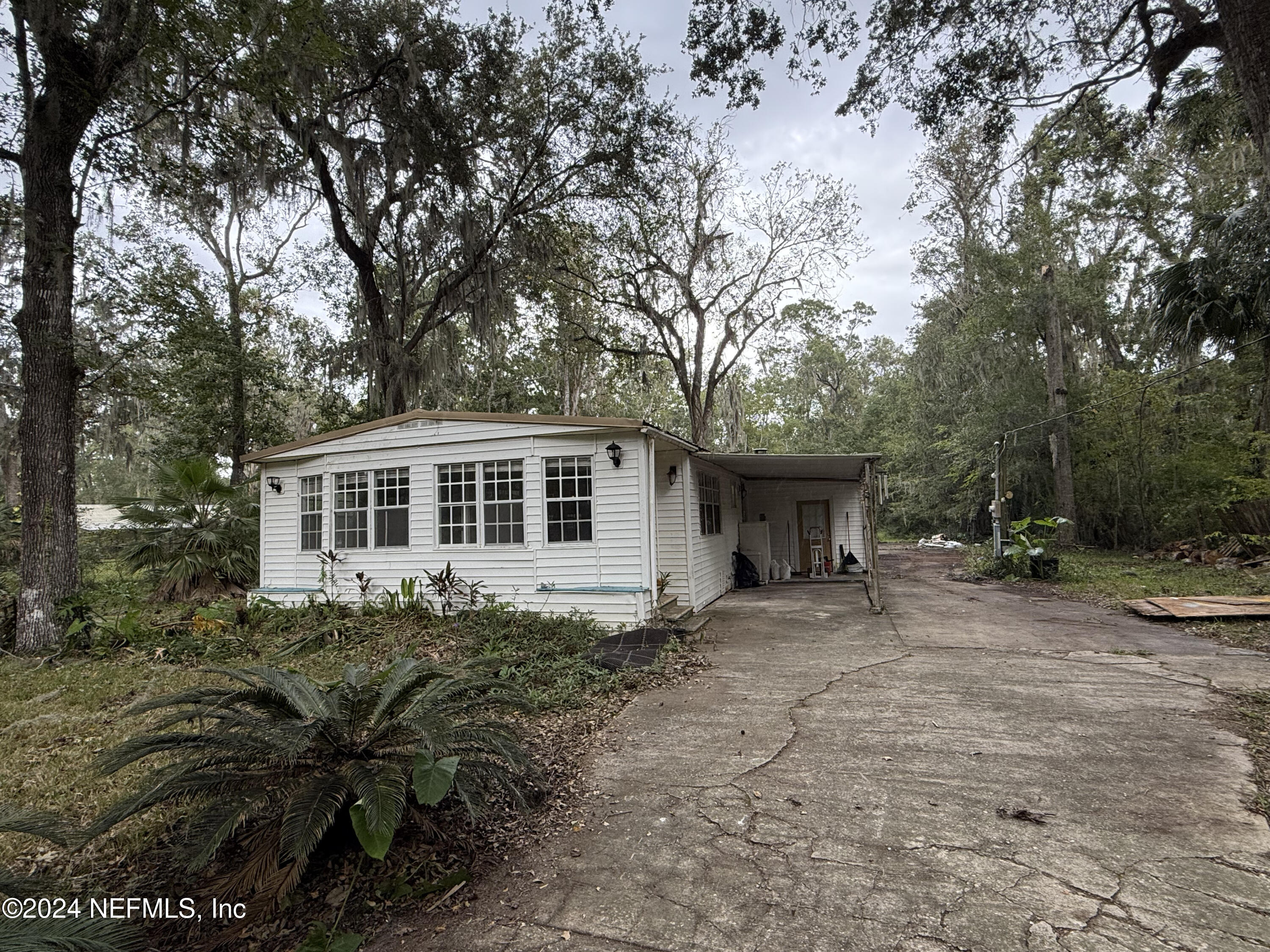 a front view of a house with yard and trees