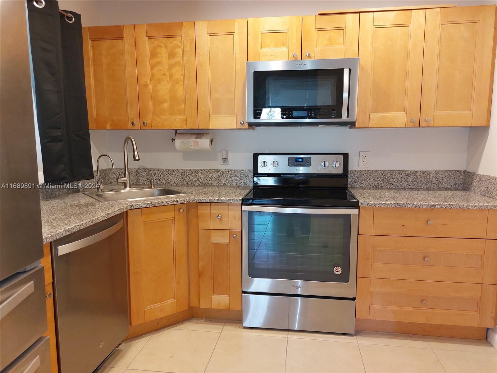 a kitchen with stainless steel appliances granite countertop a stove microwave and sink