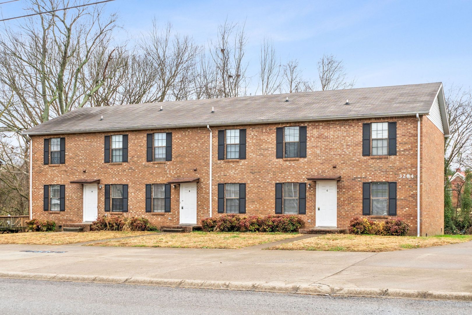 front view of a brick house with a yard