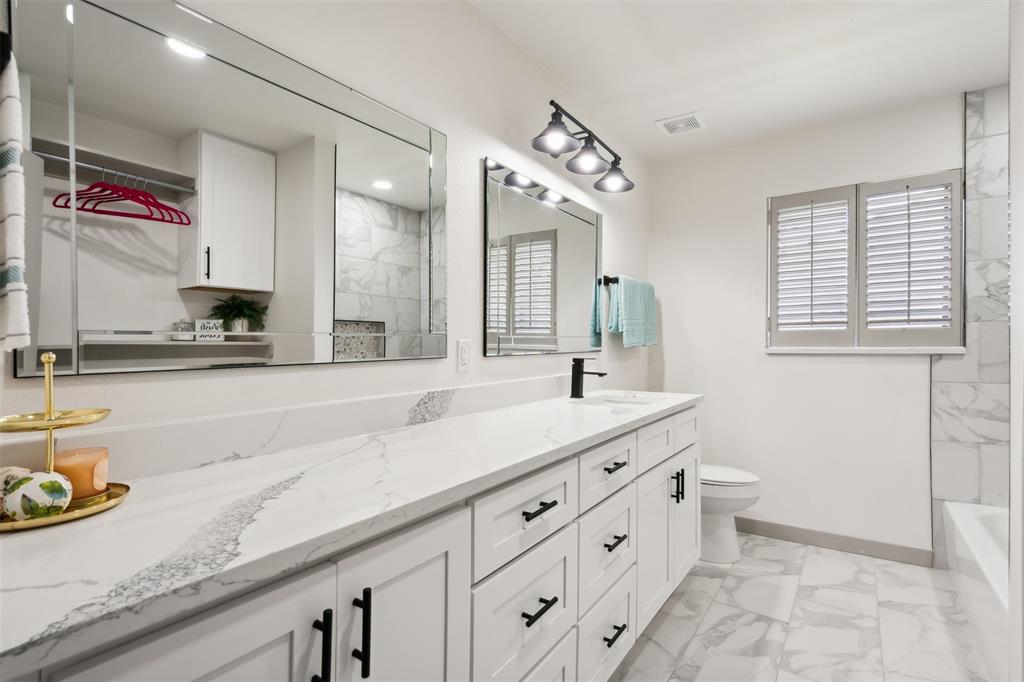 a bathroom with a granite countertop sink mirror and vanity