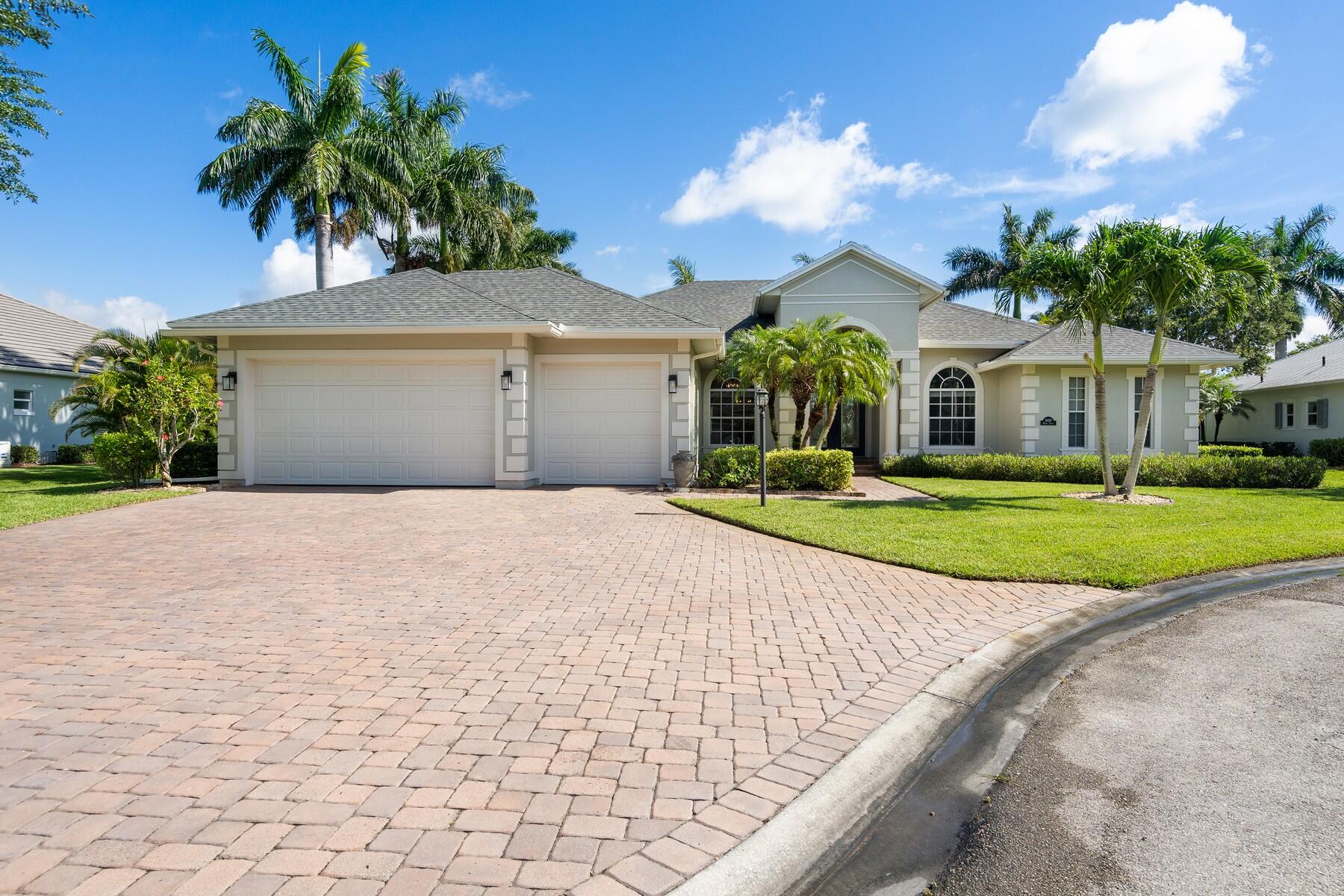 a front view of a house with a yard and potted plants