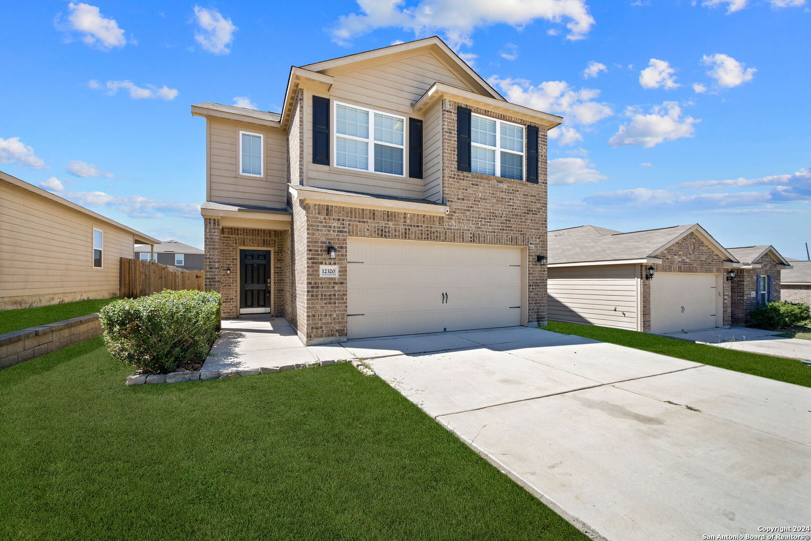 a front view of a house with a yard and garage