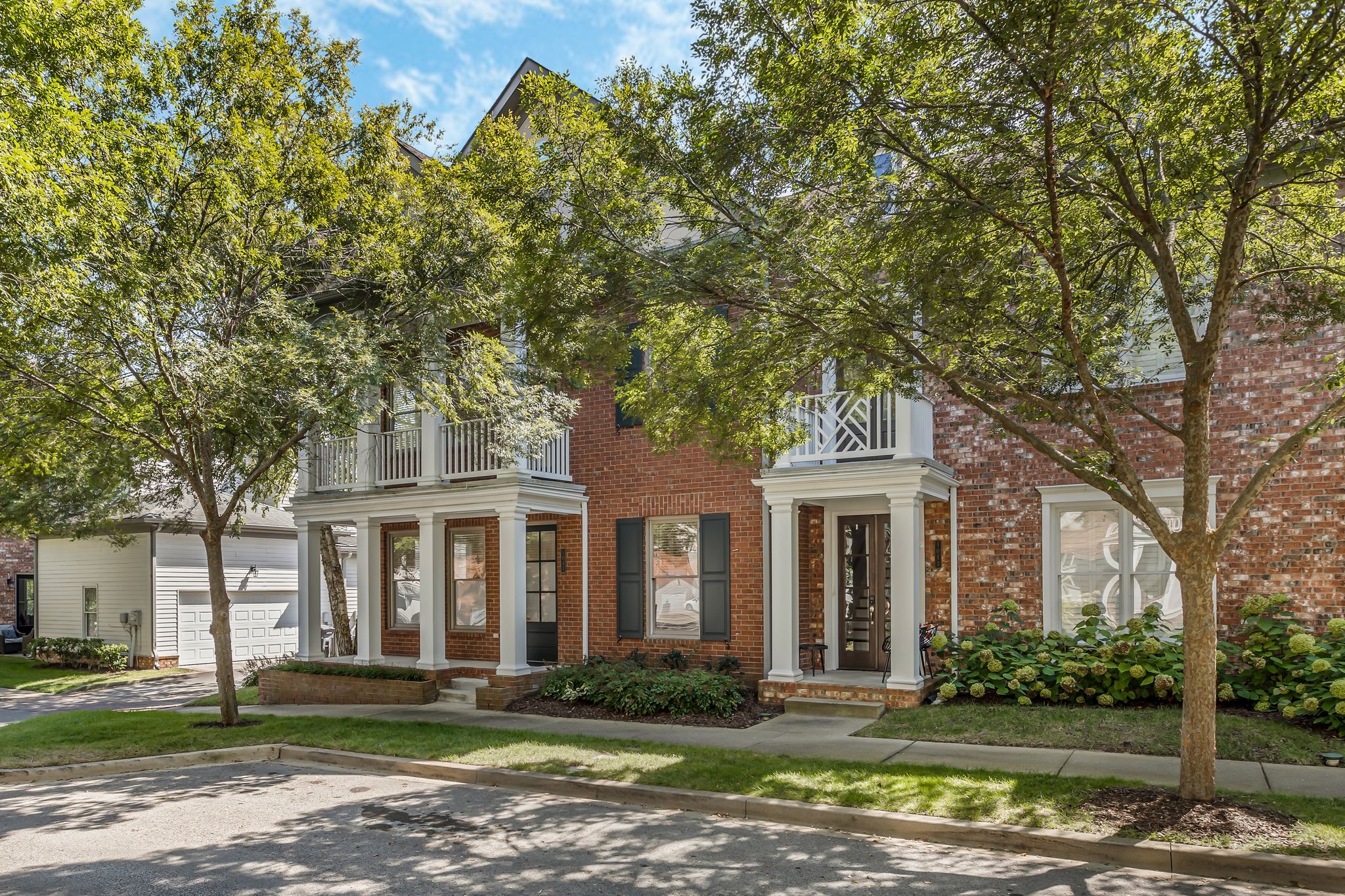 front view of a brick house with a yard