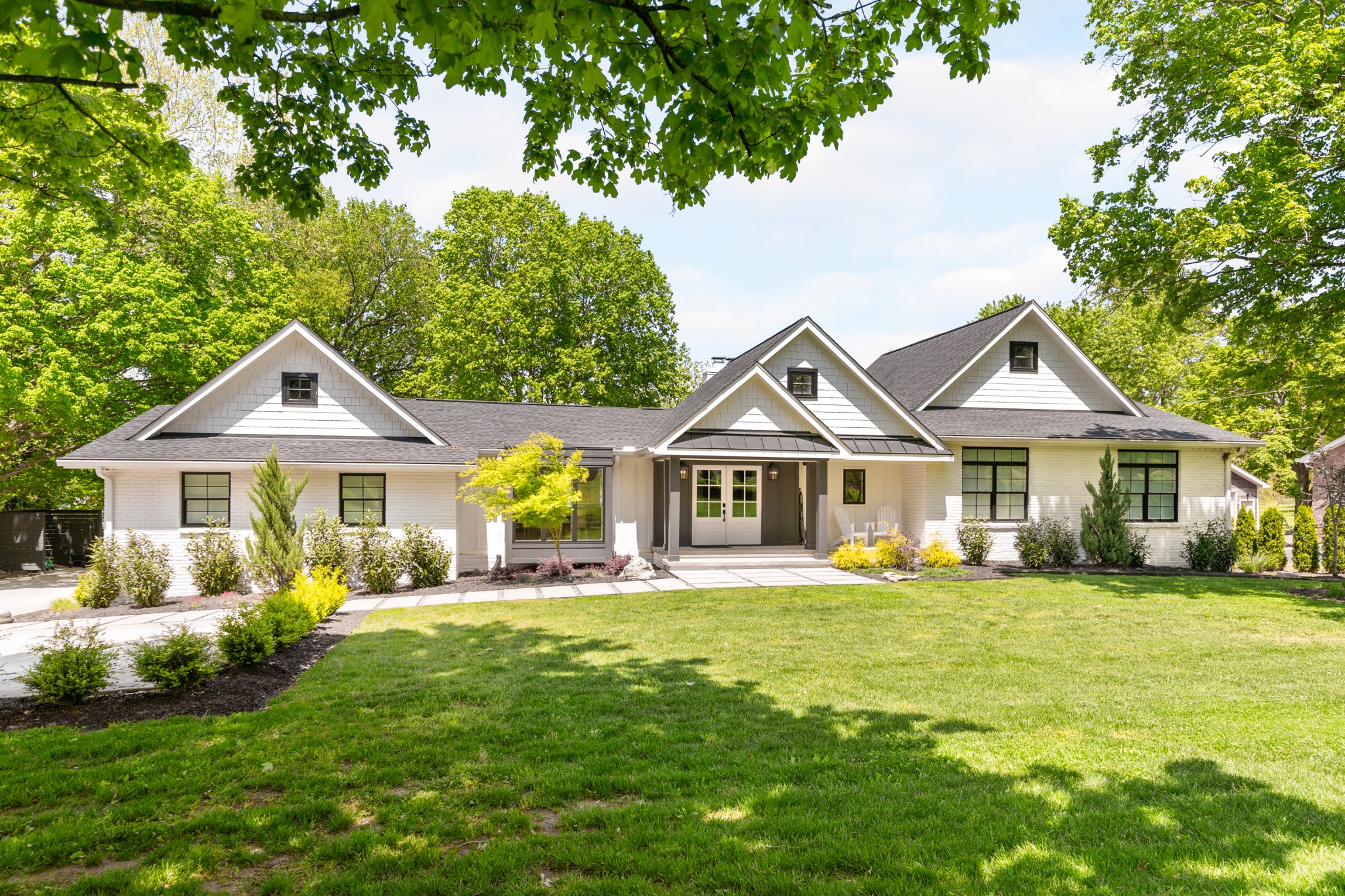 a front view of a house with a yard and trees