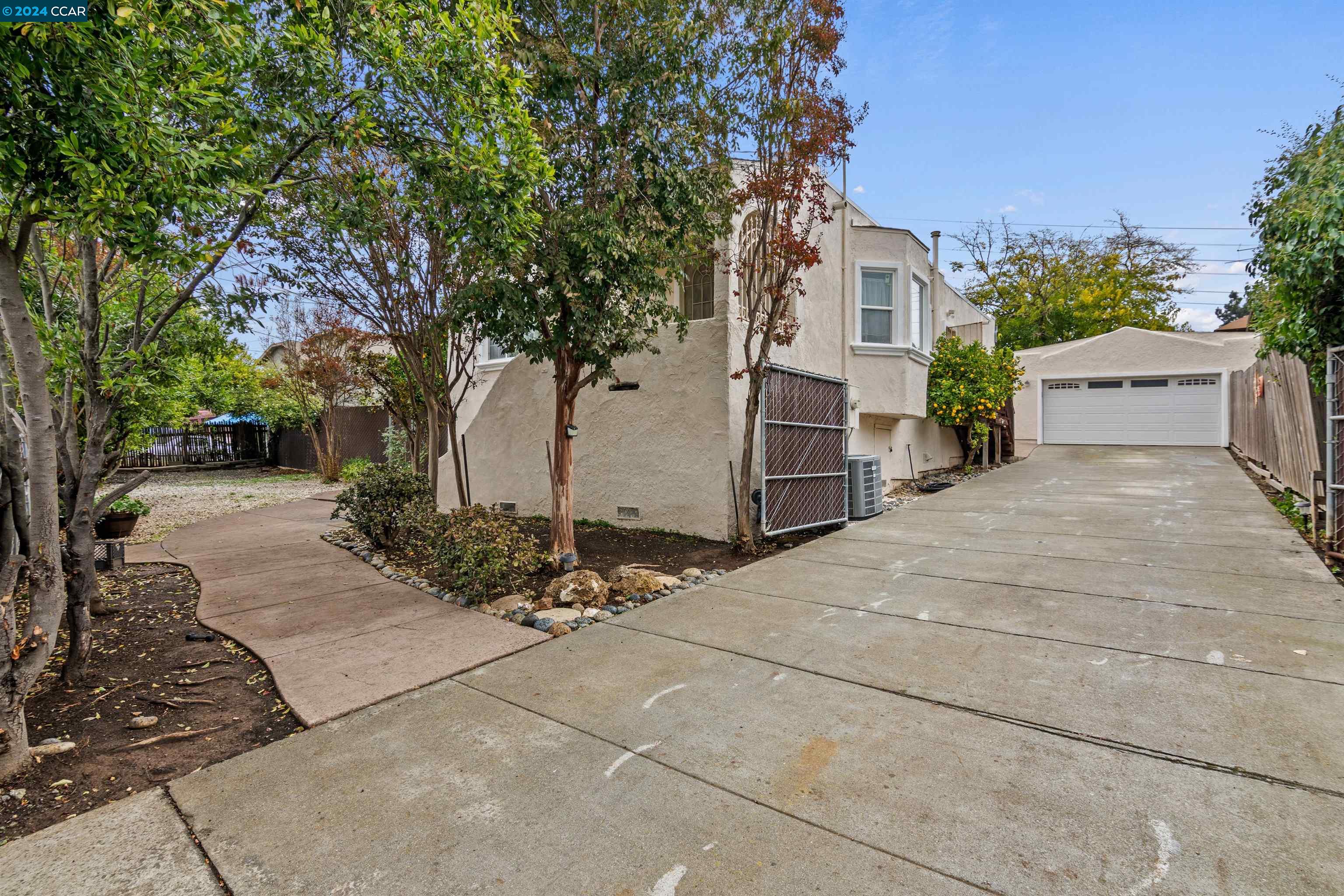 a pathway of a house with yard and trees