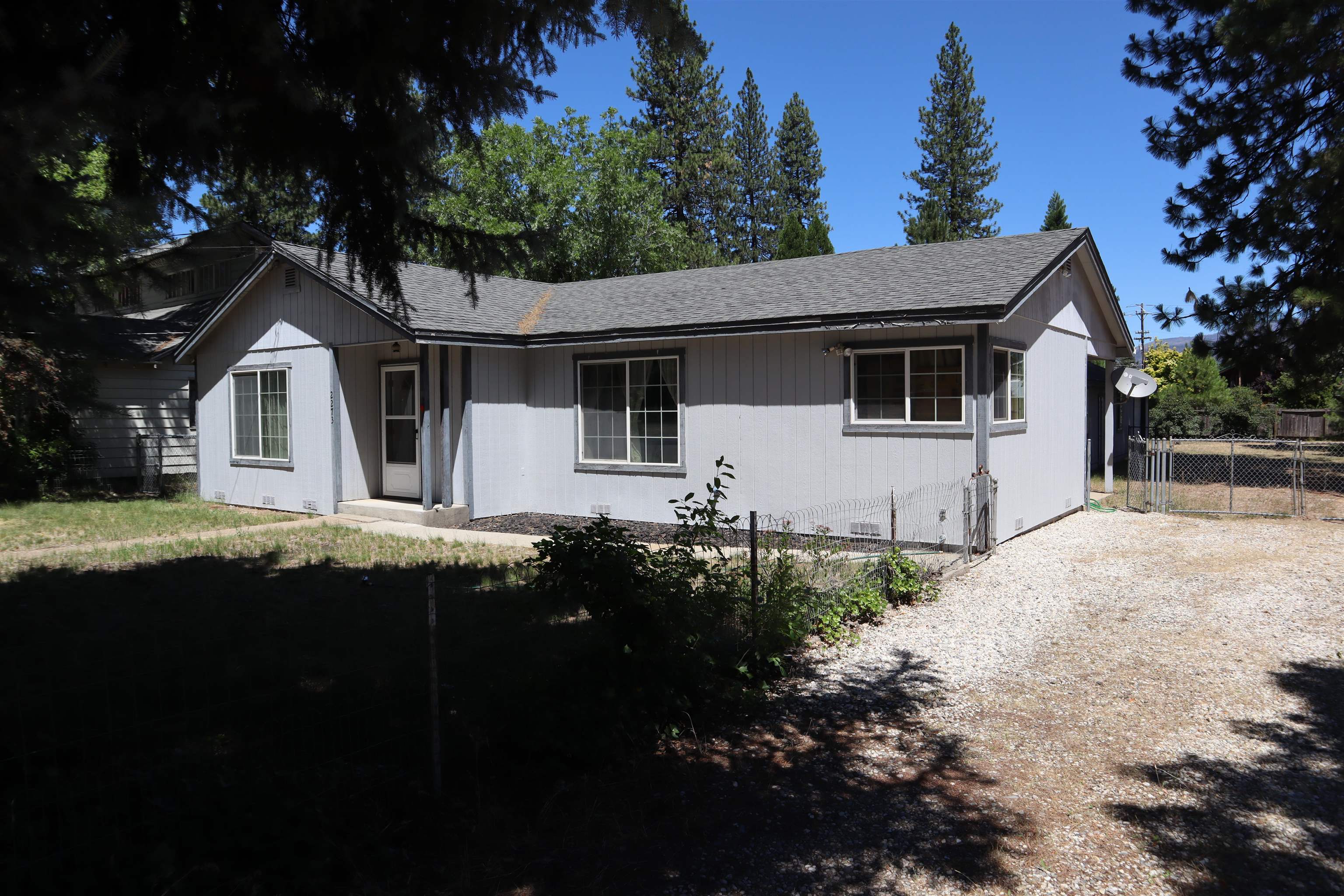 a front view of house with yard and trees around