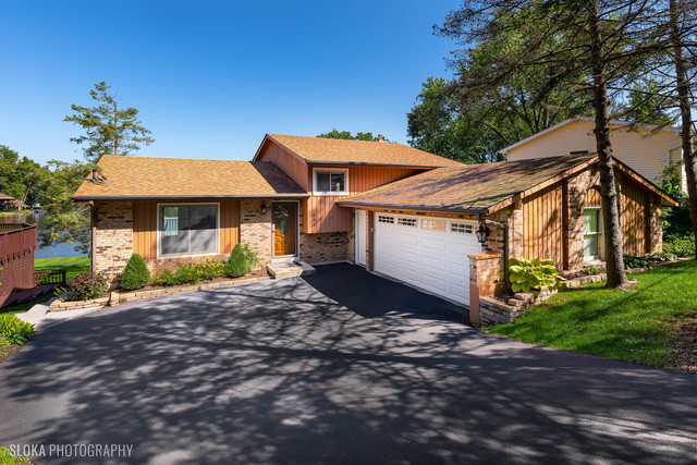 a front view of a house with a yard and a garage