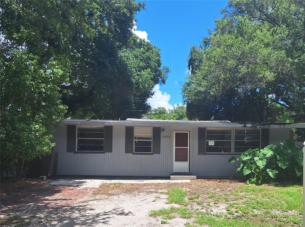 a front view of house with yard and trees around