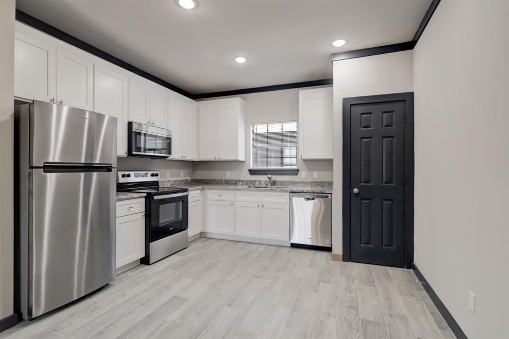 a kitchen with a refrigerator a sink and a stove top oven