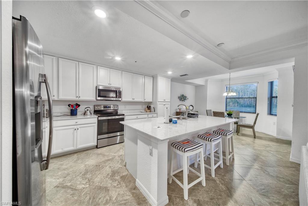 a kitchen with a sink stainless steel appliances and white cabinets