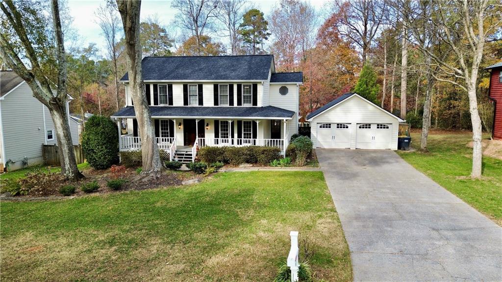 a front view of a house with a yard and trees