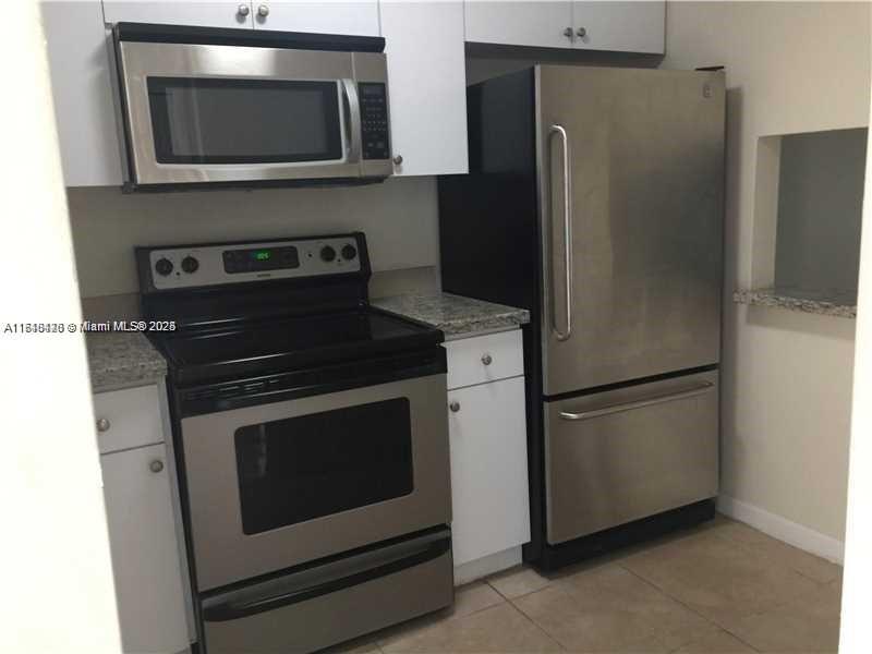 a kitchen with stainless steel appliances a refrigerator stove and microwave