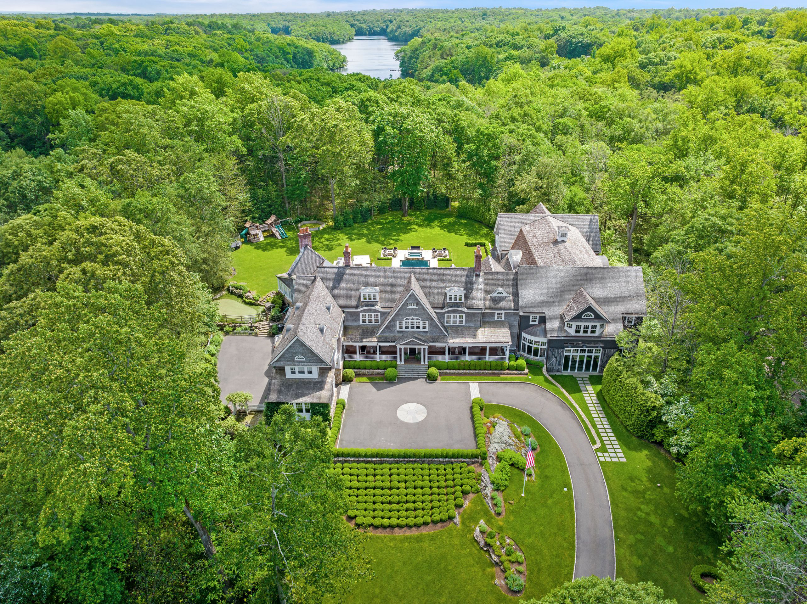 an aerial view of a house with a garden and lake view