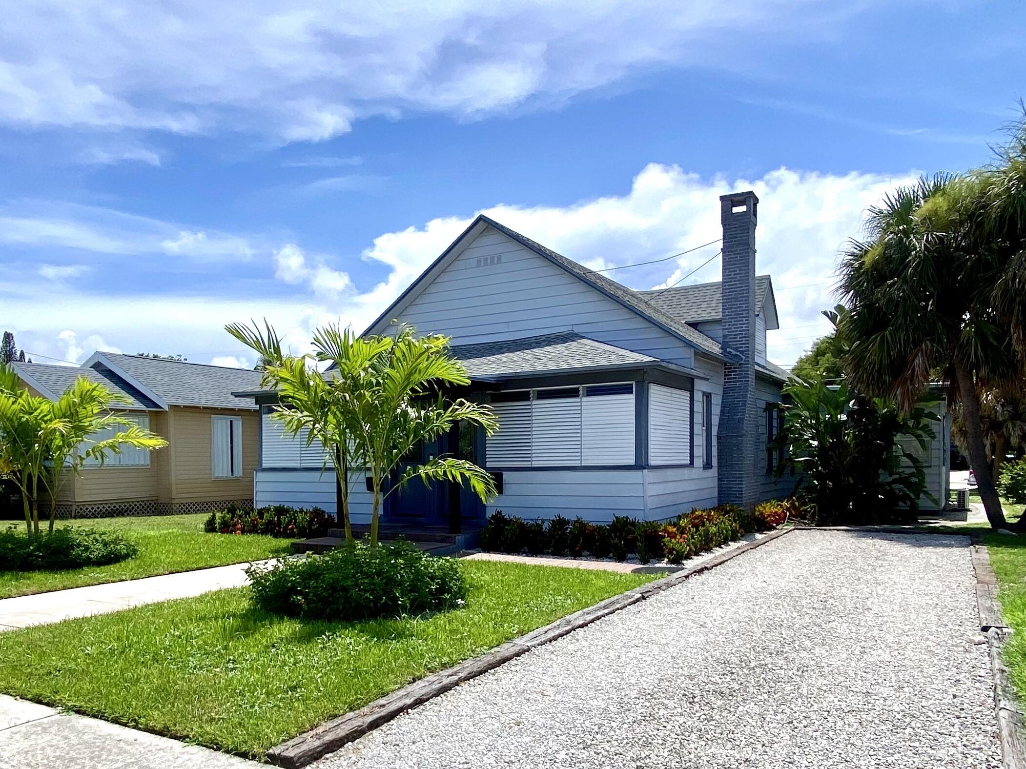 a front view of a house with a yard and potted plants