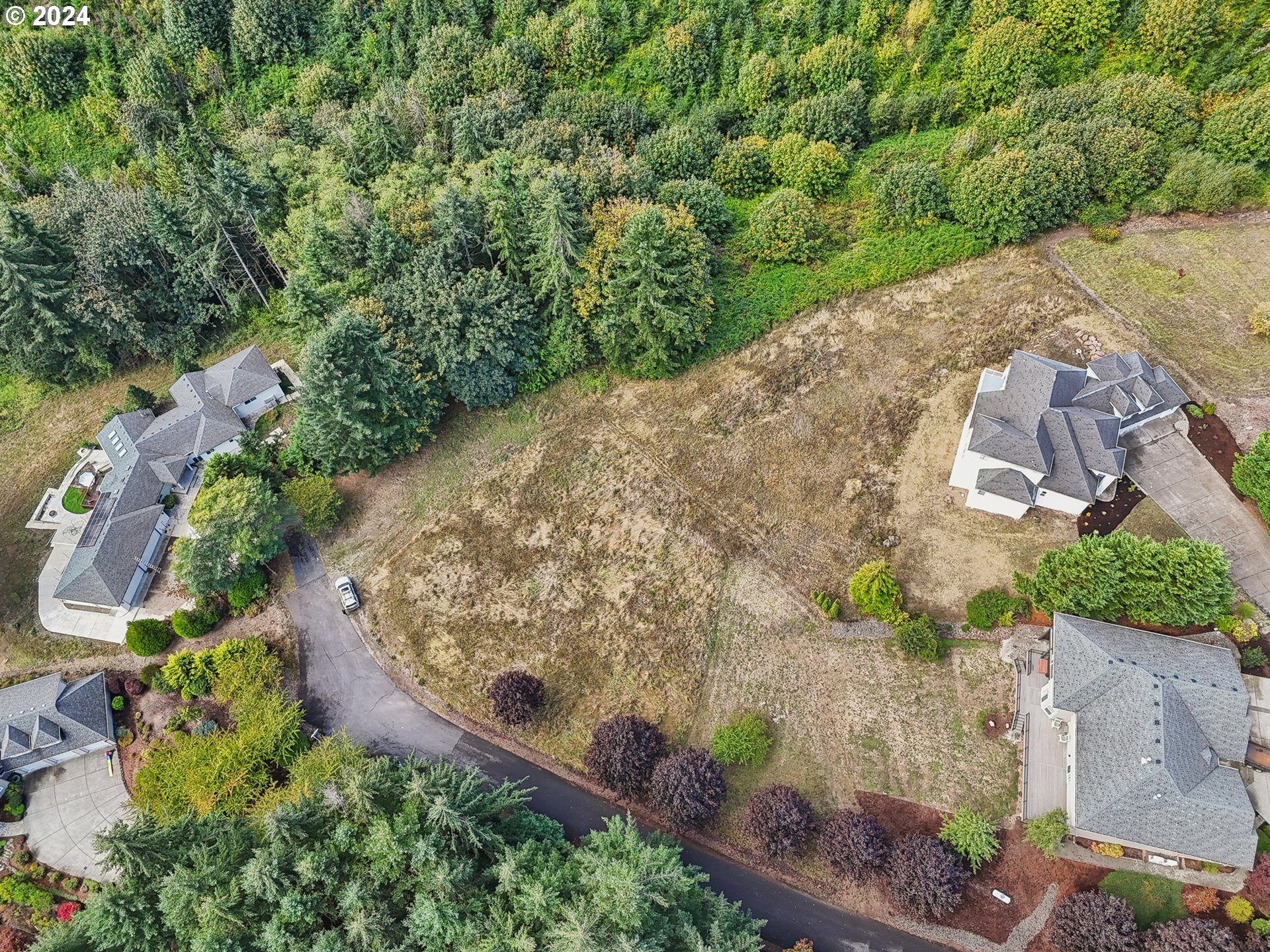 an aerial view of a house with a yard and mountains